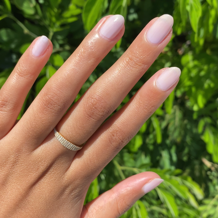 Close-up of a hand with nails painted in glossy milky lavender using Violet Bliss for a fresh at-home mani.